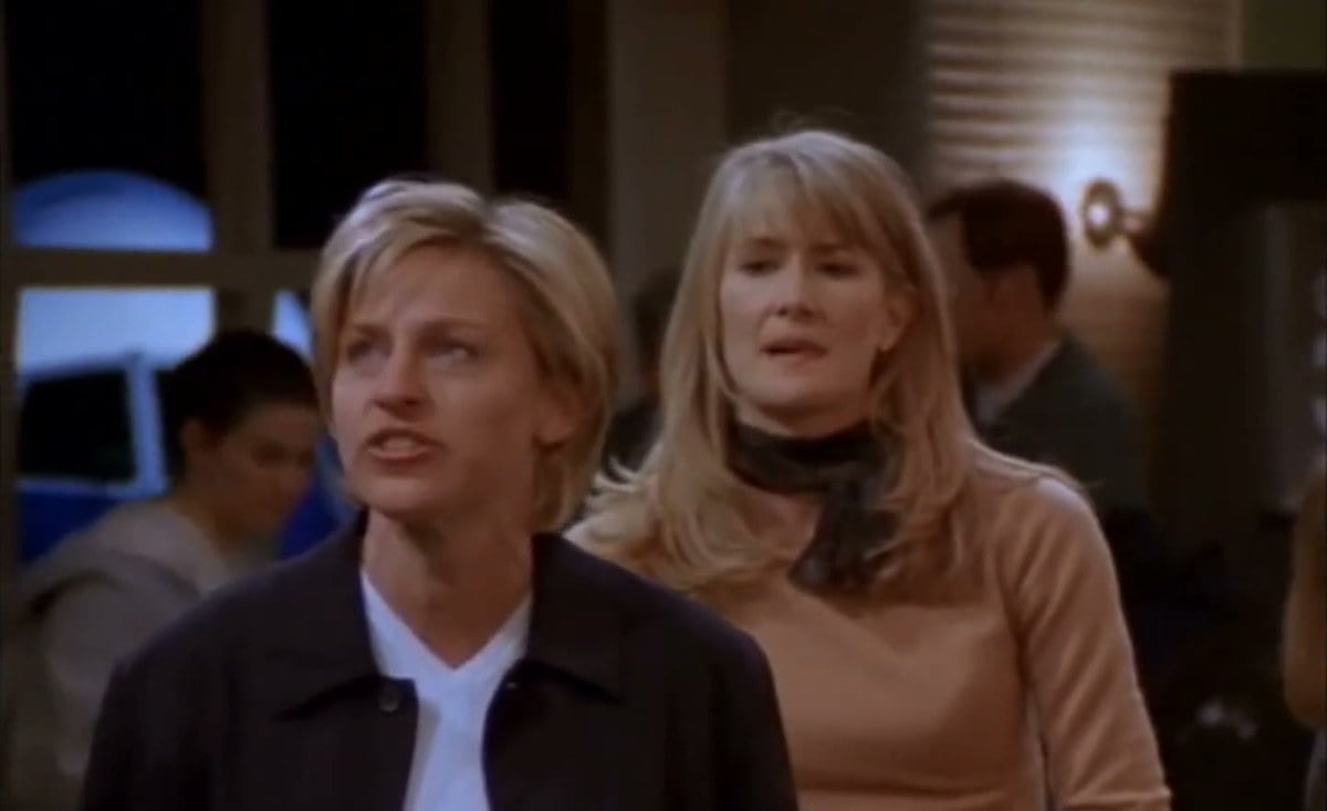Ellen DeGeneres in a dark jacket and Laura Dern in a tan sweater at an airport gate in The Puppy Episode of Ellen