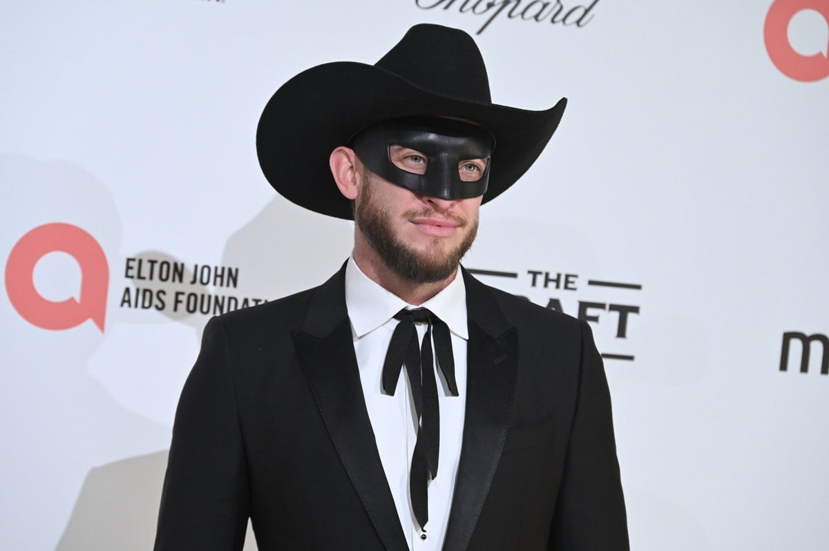Orville Peck in a black cowboy hat, mask and suit at the Elton John AIDS Foundation Oscars viewing party