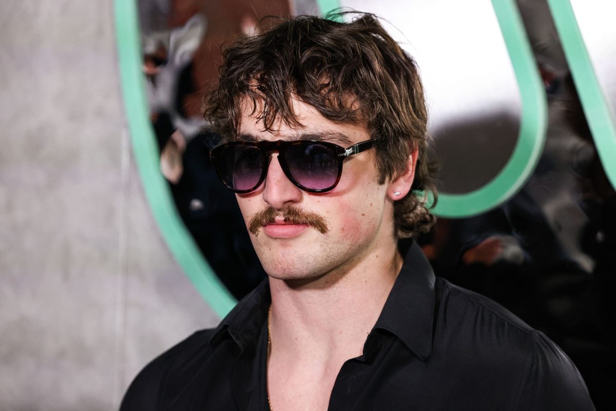 Benson Boone in sunglasses and an open-collar black shirt