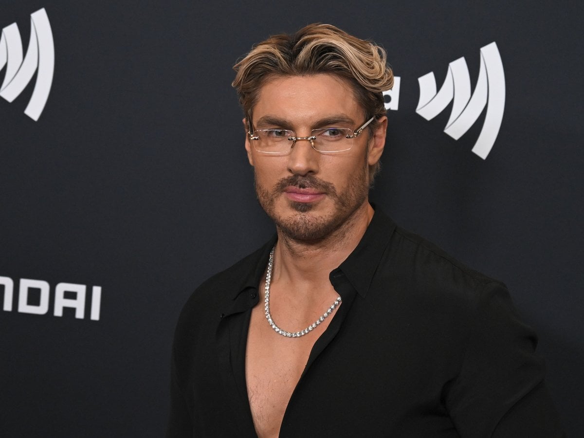Chris Appleton in glasses and an open black shirt on the red carpet