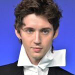 Troye Sivan with tousled dark hair and a dramatic white collar at the 2026 MTV VMAs