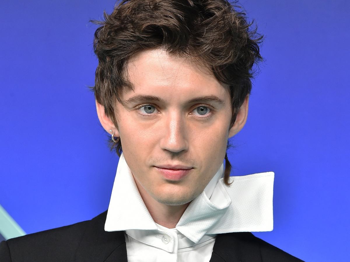 Troye Sivan with tousled dark hair and a dramatic white collar at the 2026 MTV VMAs