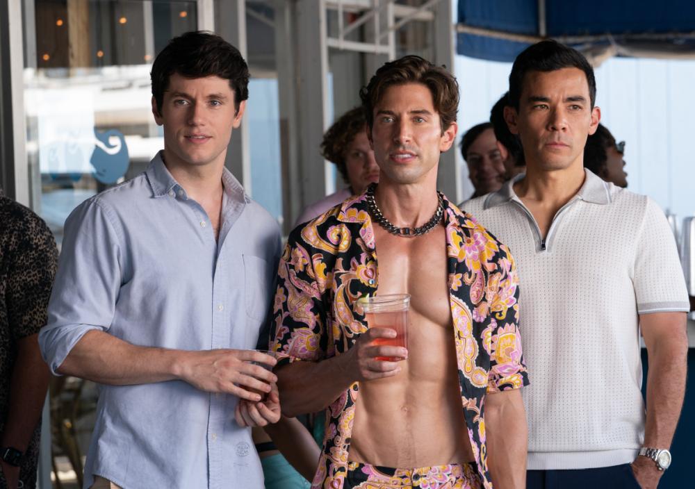 Three men in summer shirts standing together at a beach-town bar in Fire Island