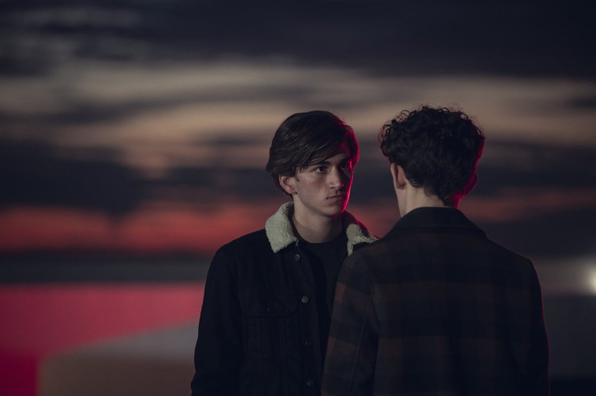 Sebastian Croft as Ben facing Joe Locke as Charlie at dusk in Heartstopper