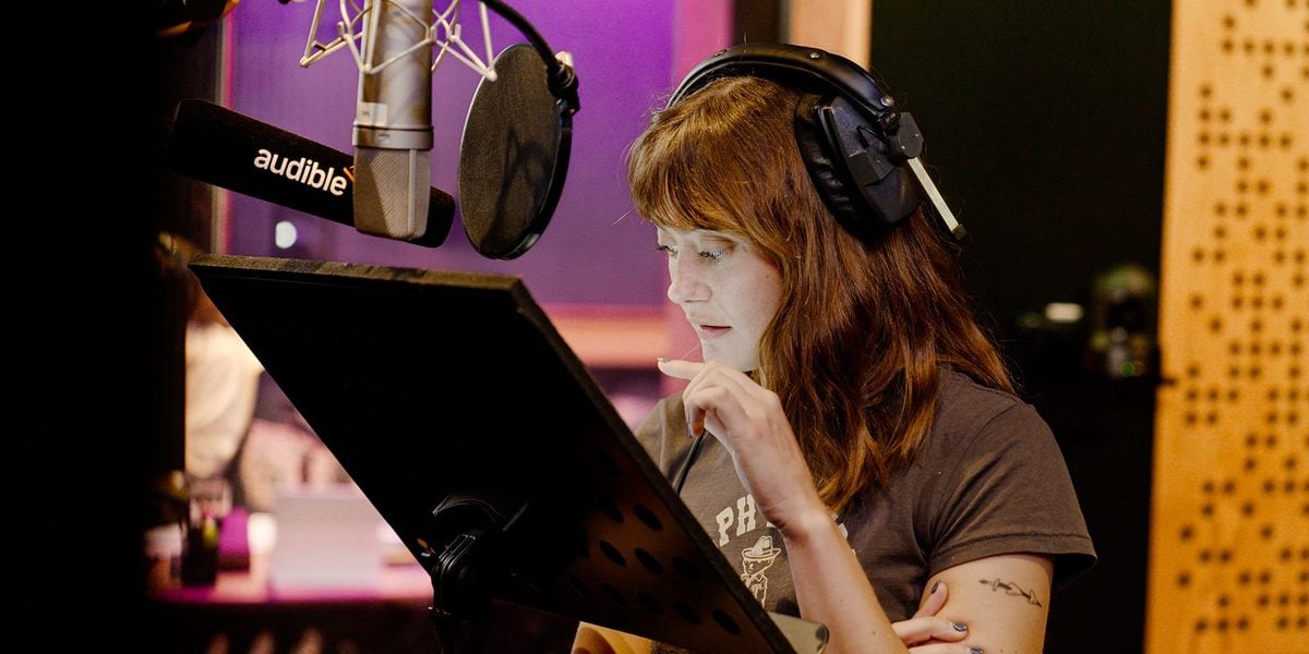 Ella Purnell in headphones reading her script in a recording booth