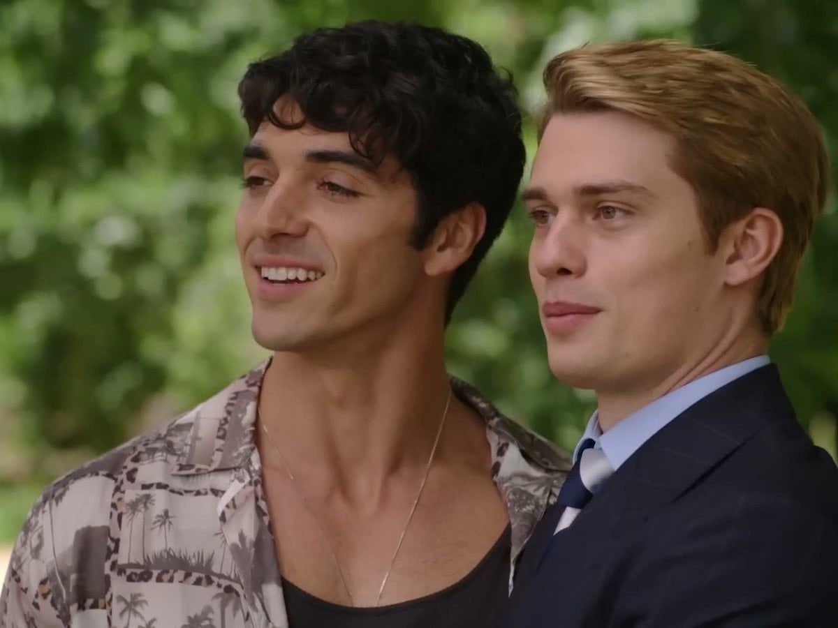 Taylor Zakhar Perez and Nicholas Galitzine smiling side by side in a garden in Red, White & Royal Blue