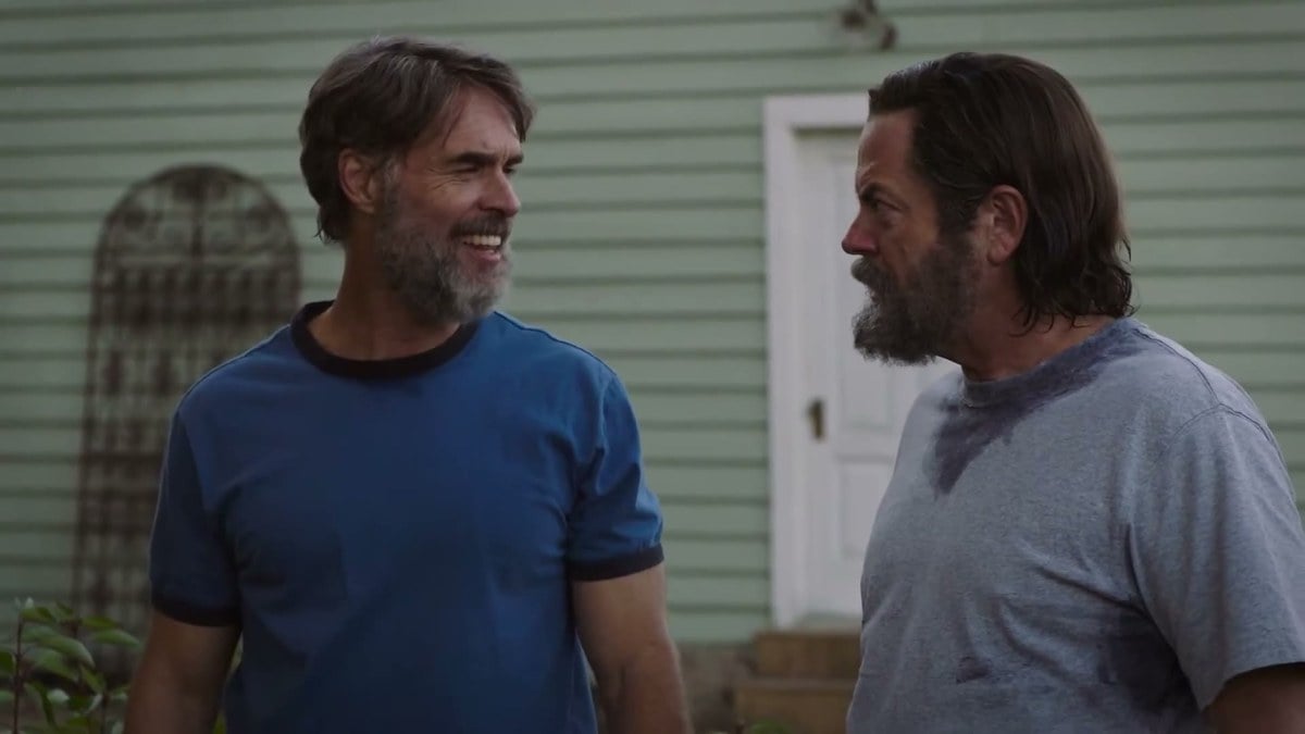 Murray Bartlett as Frank laughing at Nick Offerman as Bill outside a green house in The Last of Us