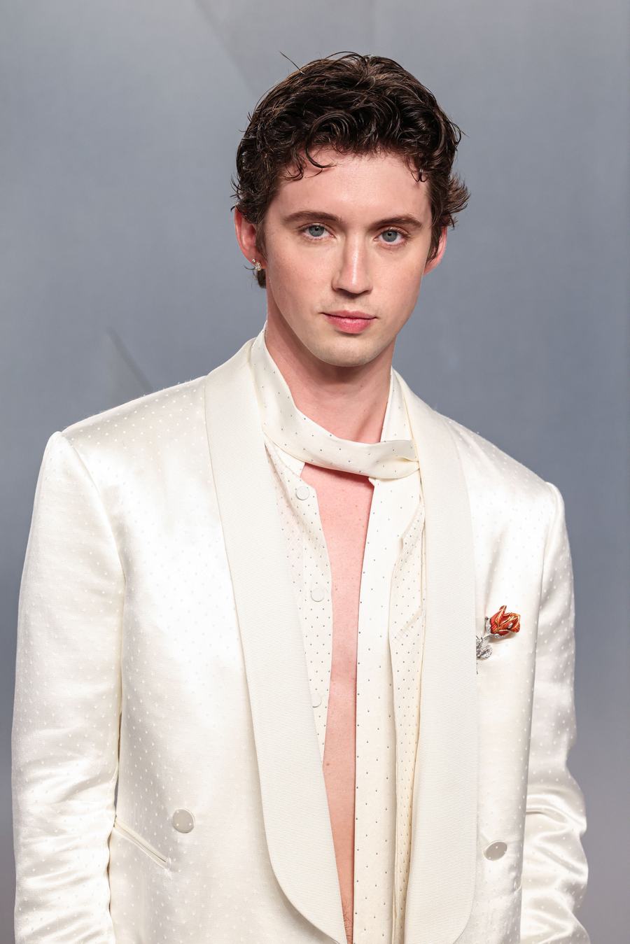 Troye Sivan in a cream satin suit and pale pink scarf at the 2026 Vanity Fair Oscar Party
