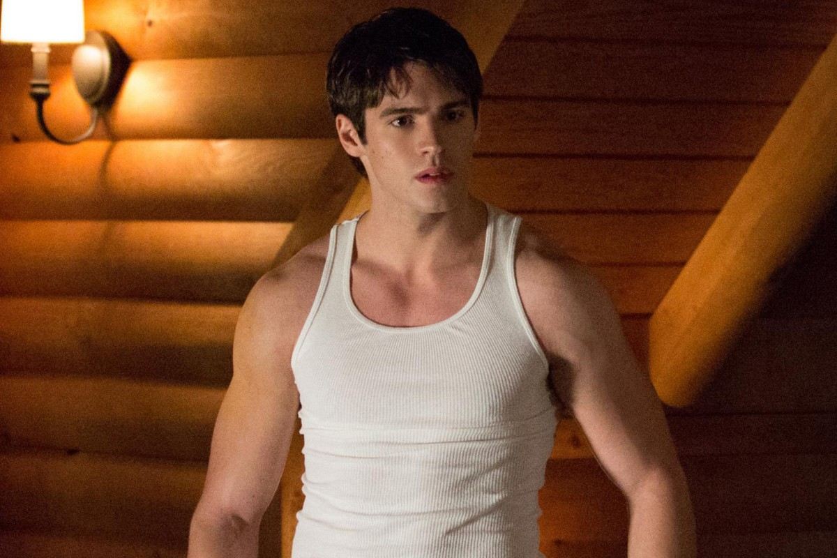 Steven R. McQueen as Jeremy Gilbert in a white tank top in a log cabin